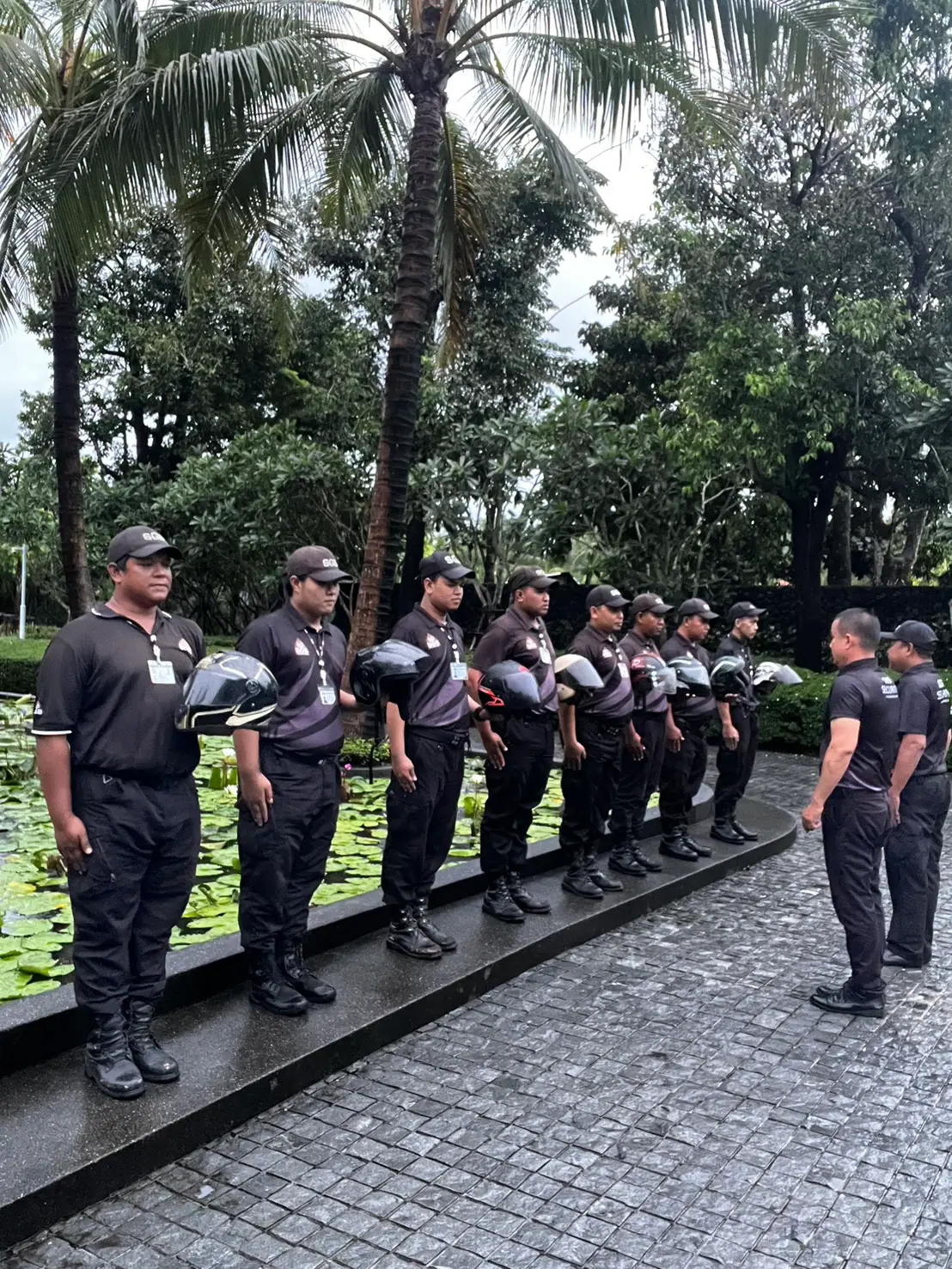 SGS motorcycle patrol officers holding helmets on parade at Anchan Villas, Phuket