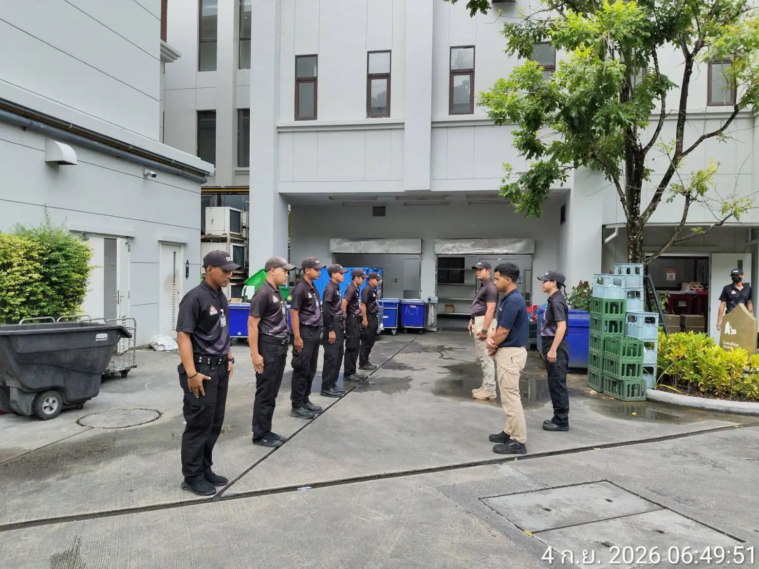 Two SGS supervisors inspecting a line of seven security officers standing to attention beside the loading bay at InterContinental Phuket Resort, Kamala